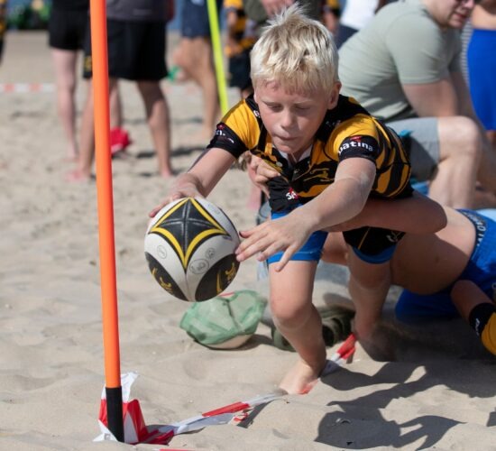 Rugbyende kinderen op beach rugby toernooi